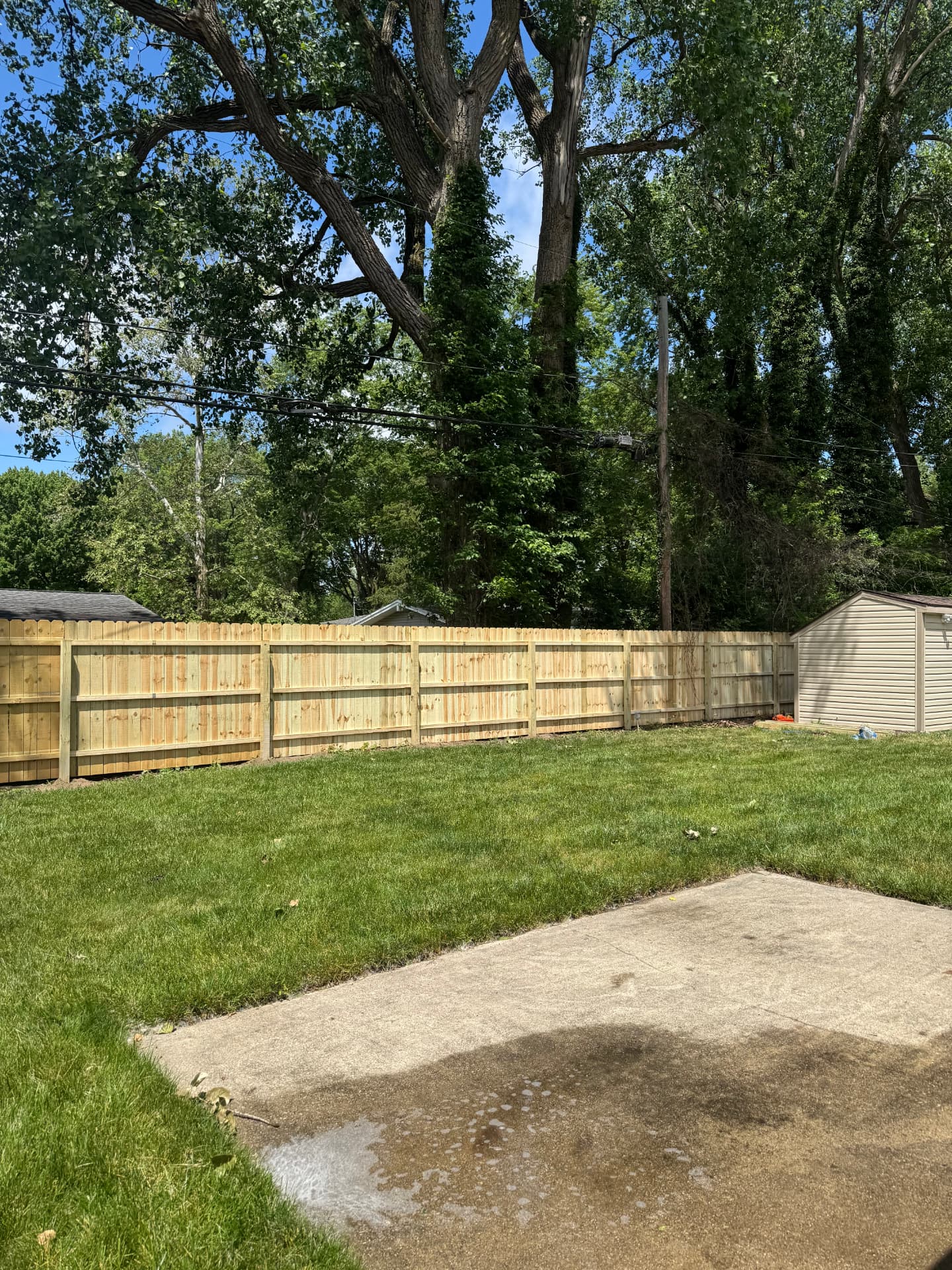 Completed wood privacy fence along the back property line of a Toledo-area home