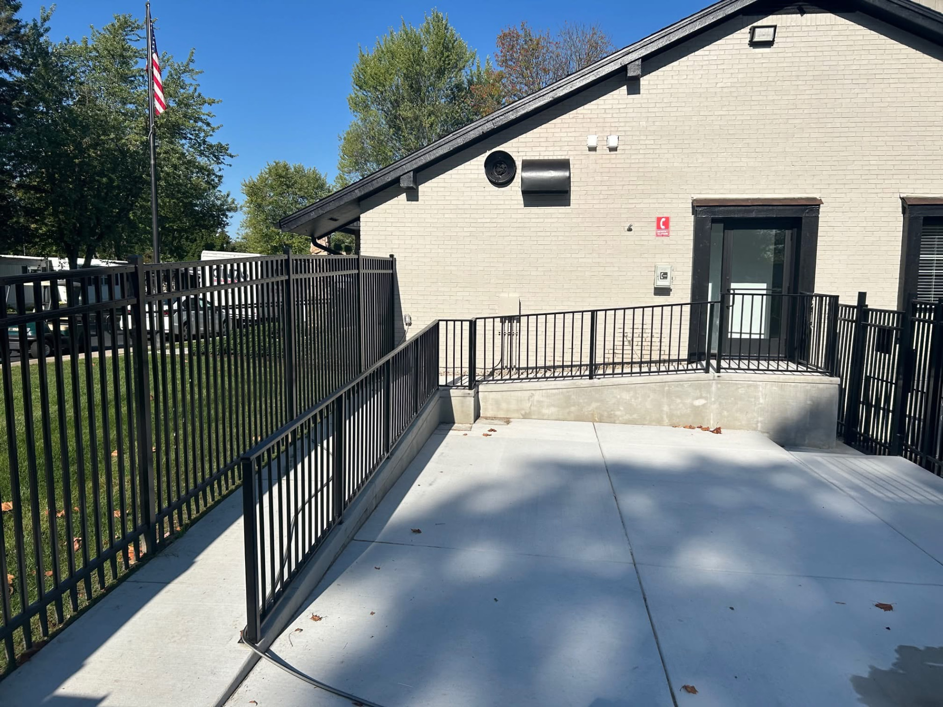 Black aluminum ornamental fence enclosing a concrete patio at a clubhouse in the Toledo area