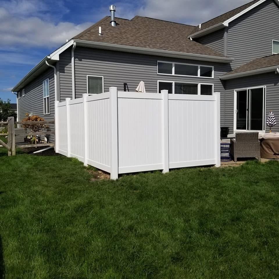 White vinyl privacy fence enclosing a back patio at a two-story home in the Toledo area